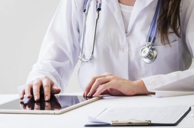 close-up-female-doctor-using-digital-tablet-medical-report-desk